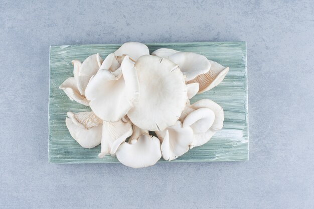 Fresh organic oyster mushrooms on wooden board. 