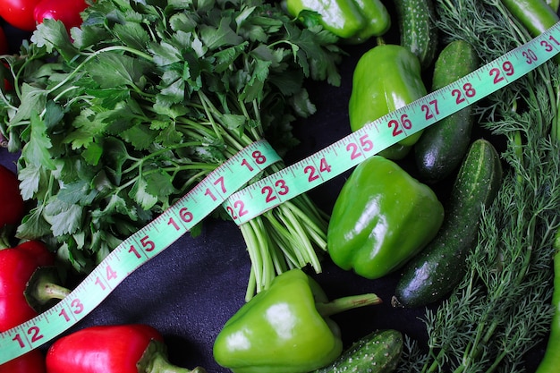 Fresh organic parsley, tomatoes, red peppers, green peppers, fennel, dill and cucumber with green centimeter top view, diet concept