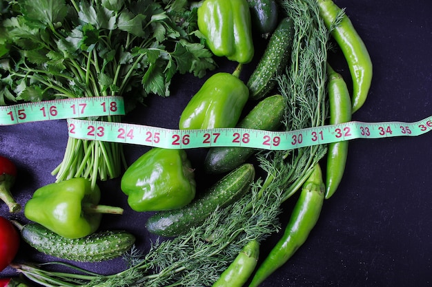 Fresh organic parsley, tomatoes, red peppers, green peppers, fennel, dill and cucumber with green centimeter top view, diet concept