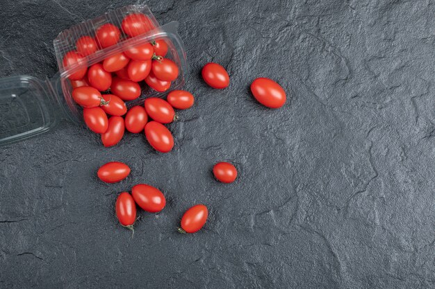 黒の背景に新鮮な有機の小さな赤いトマト。高品質の写真