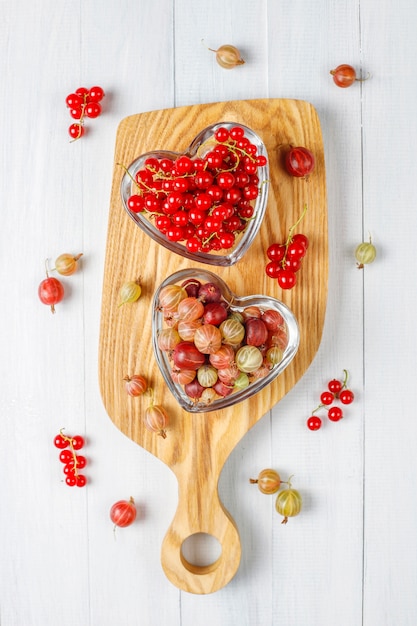 Free photo fresh organic sweet gooseberries and red currants in bowls