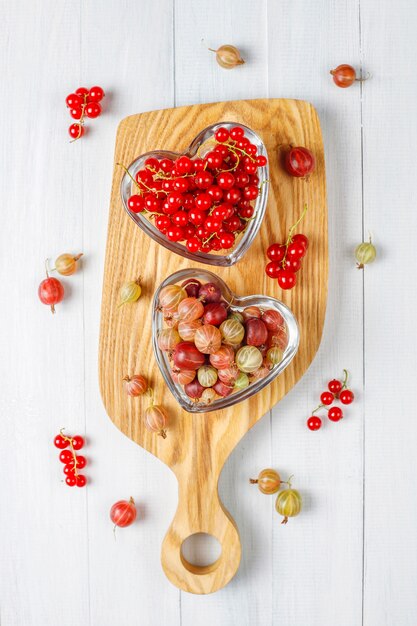 Fresh organic sweet gooseberries and red currants in bowls