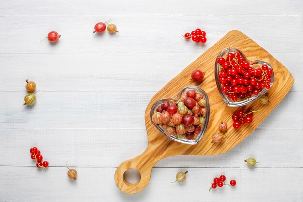 Fresh organic sweet gooseberries and red currants in bowls