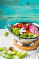 Free photo fresh organic vegetables in colander over marble tabletop