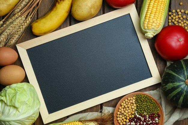 Fresh organic vegetables,fruits,eggs,beans,and corns with blackboard on vintage wooden table