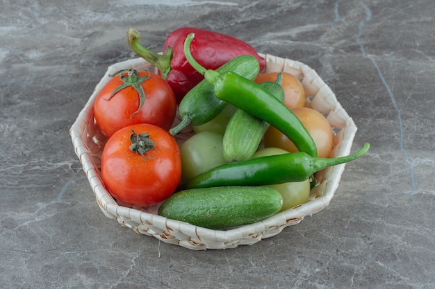 Бесплатное фото Свежие органические овощи в корзине на серой поверхности