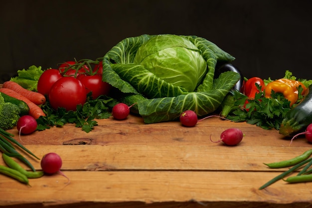 Fresh organic vegetables on a wooden boards background, top view. Healthy food concept.