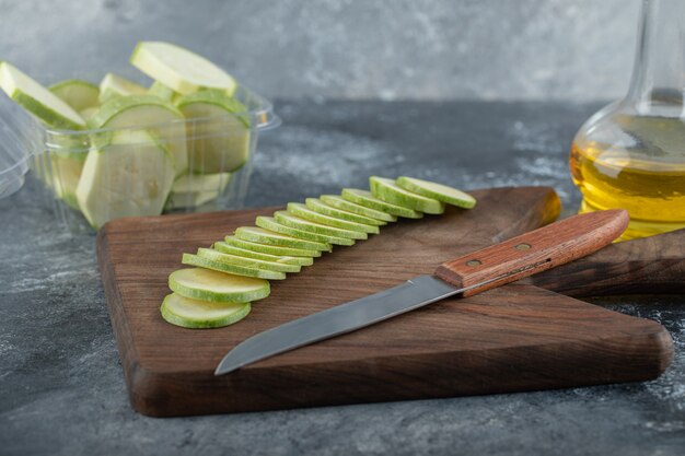 Fresh organic zucchini slices on wooden board .