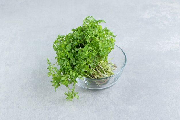 A fresh parsley in the glass , on the marble.
