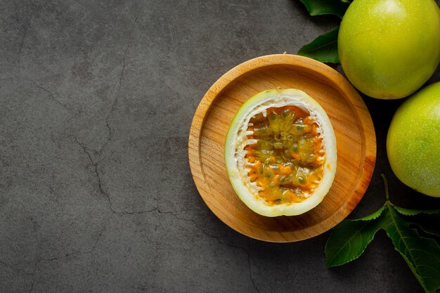 fresh passion fruit cut in half place on wooden plate