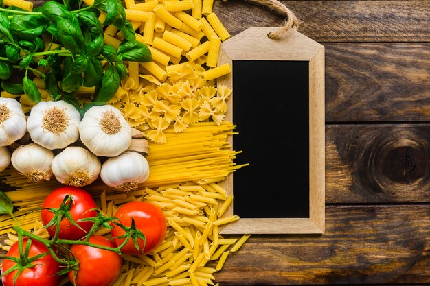Fresh pasta ingredients near blackboard