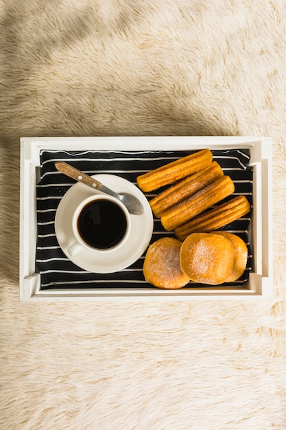 Fresh pastry near coffee on tray