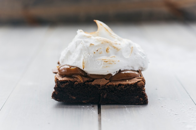 Fresh pastry with whipped cream on wooden surface