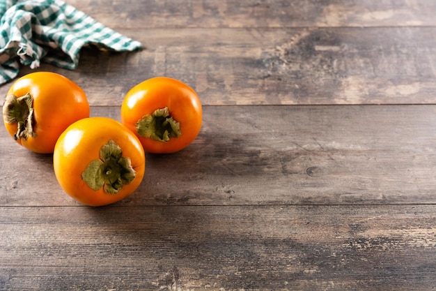 Fresh persimmon fruit on wooden table