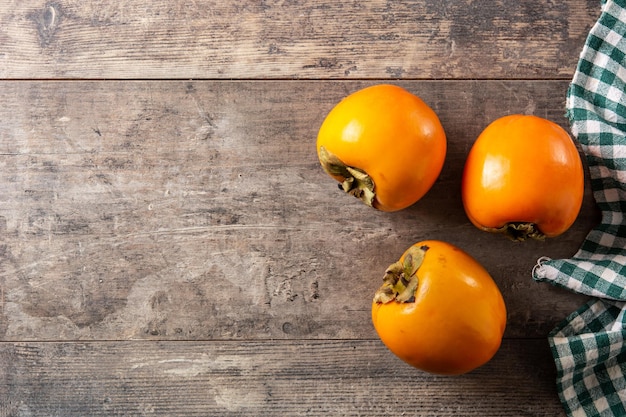 Fresh persimmon fruit on wooden table