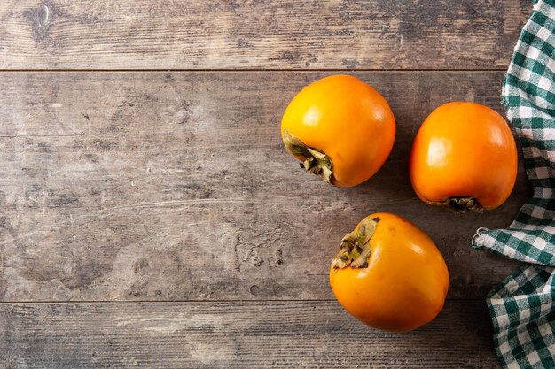 木製のテーブルに新鮮な柿の果実