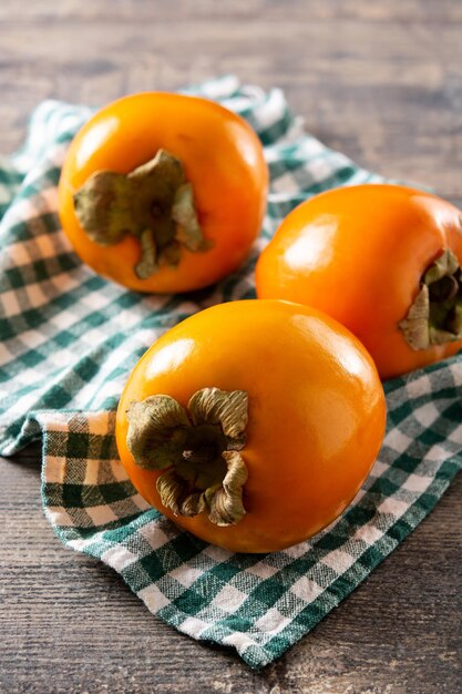 Fresh persimmon fruit on wooden table