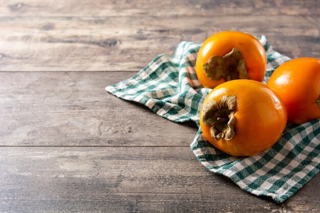 Fresh persimmon fruit on wooden table