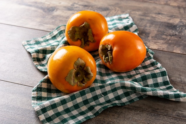 Fresh persimmon fruit on wooden table