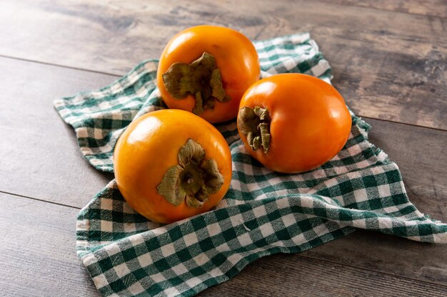 Fresh persimmon fruit on wooden table