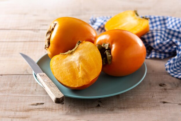 Fresh persimmon fruit on wooden table