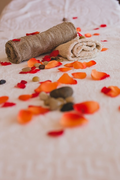 Free photo fresh petals and stones with towels