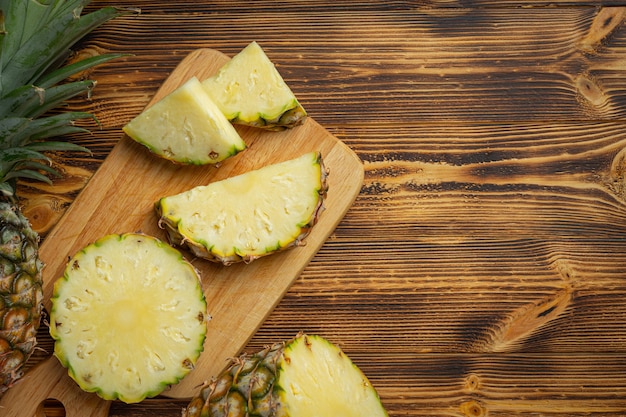 Fresh pineapple on dark wooden surface