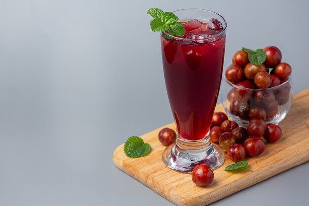 Fresh plums juice on gray surface.