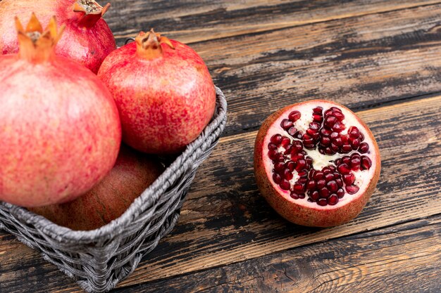 fresh pomegranate in basket top view on wooden table