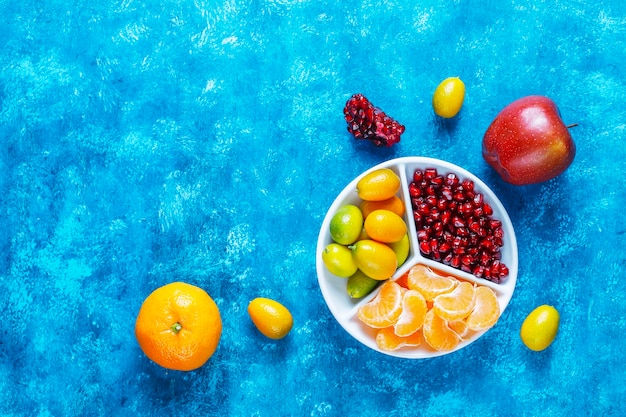 Free photo fresh pomegranate seeds,mandarin slices and kumquat fruits.