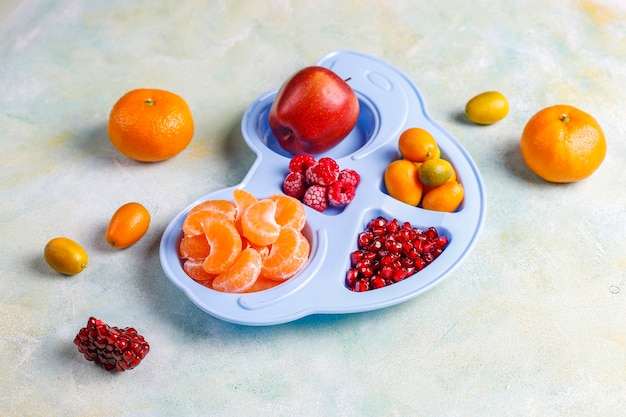 Fresh pomegranate seeds, tangerines slices and kumquat fruits.