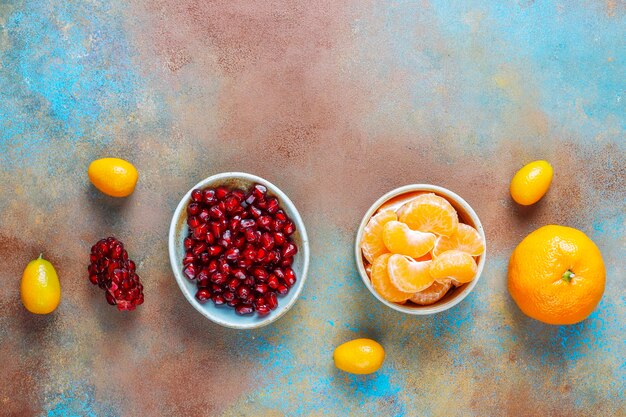 Fresh pomegranate seeds, tangerines slices and kumquat fruits.