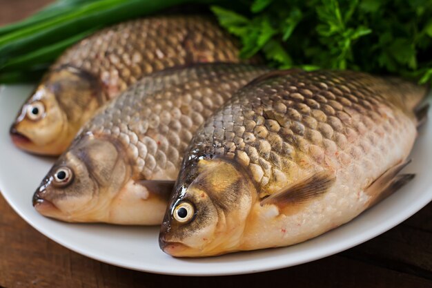 fresh raw crucian on a wooden with herbs