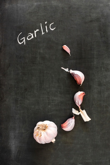 Fresh raw garlic and cloves on blackboard