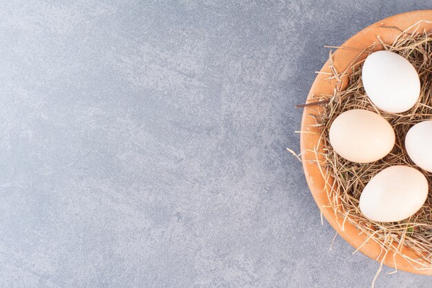 木製のボウルに新鮮な生の白い鶏の卵。