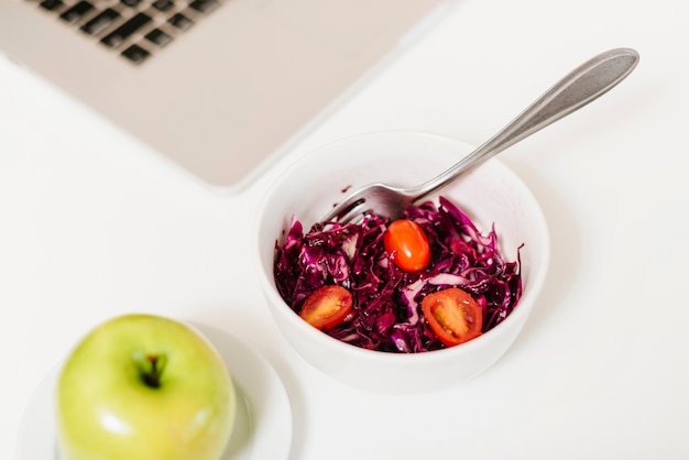 Free photo fresh red cabbage and tomatoes in bowl on desk