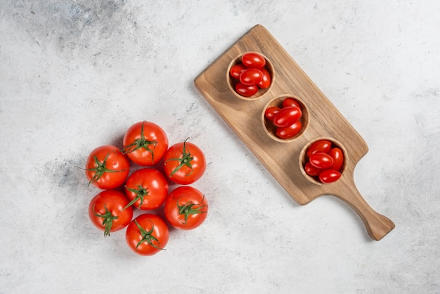 Fresh red cherry tomatoes in wooden bowls.