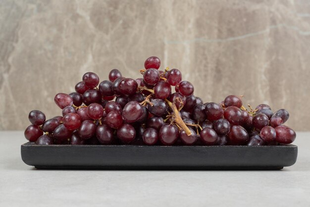 Fresh red grapes on black plate