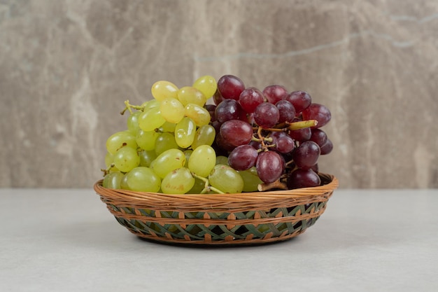 Fresh red and green grapes in wooden basket