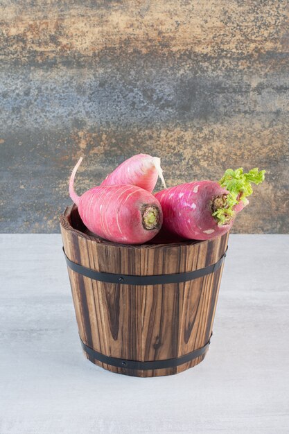 Fresh red radishes in wooden bucket. High quality photo