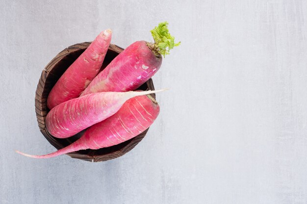 Free photo fresh red radishes in wooden bucket. high quality photo