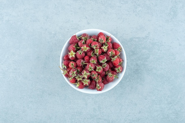 Fresh red raspberries in white bowl.