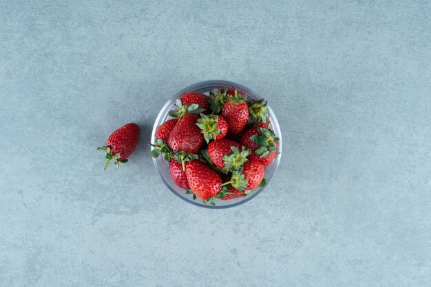 Fresh red strawberries in glass bowl.