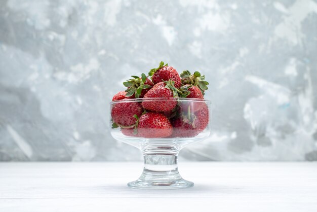 fresh red strawberries inside transparent plate on light white