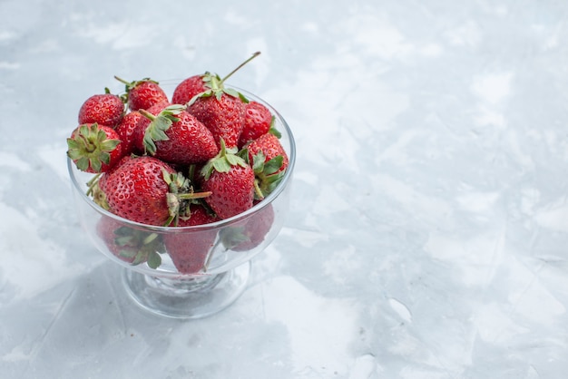 Fresh red strawberries mellow summer berries inside glass plate on light