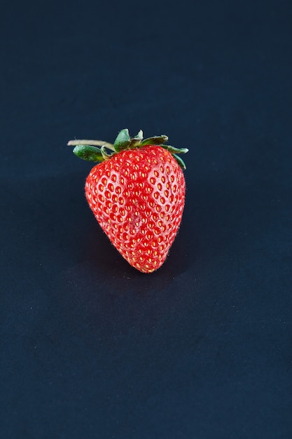 Fresh red strawberry on dark surface. Close up