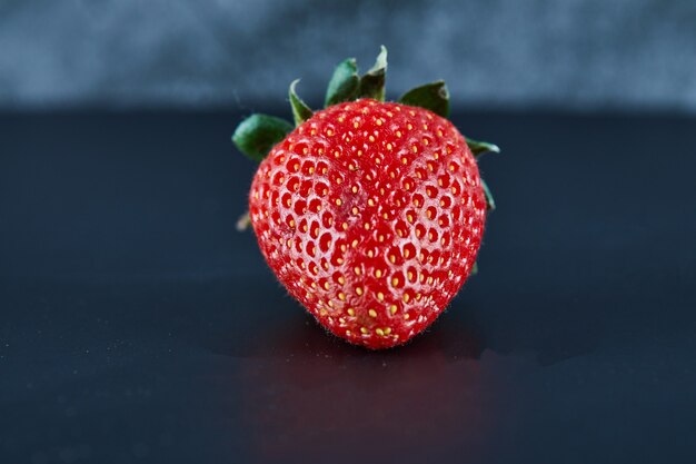 Fresh red strawberry on dark surface. Close up