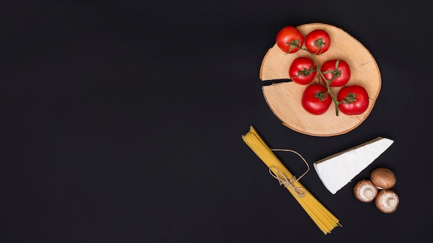신선한 빨간 토마토; 치즈; 버섯과 부엌 worktop에 스파게티 파스타의 무리