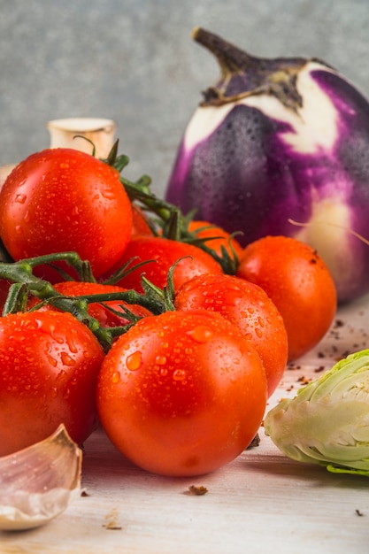 신선한 빨간 토마토; 마늘 쪽; 브뤼셀 콩나물; 나무 표면에 가지