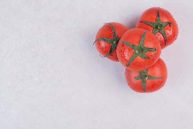 Fresh red tomatoes on white.